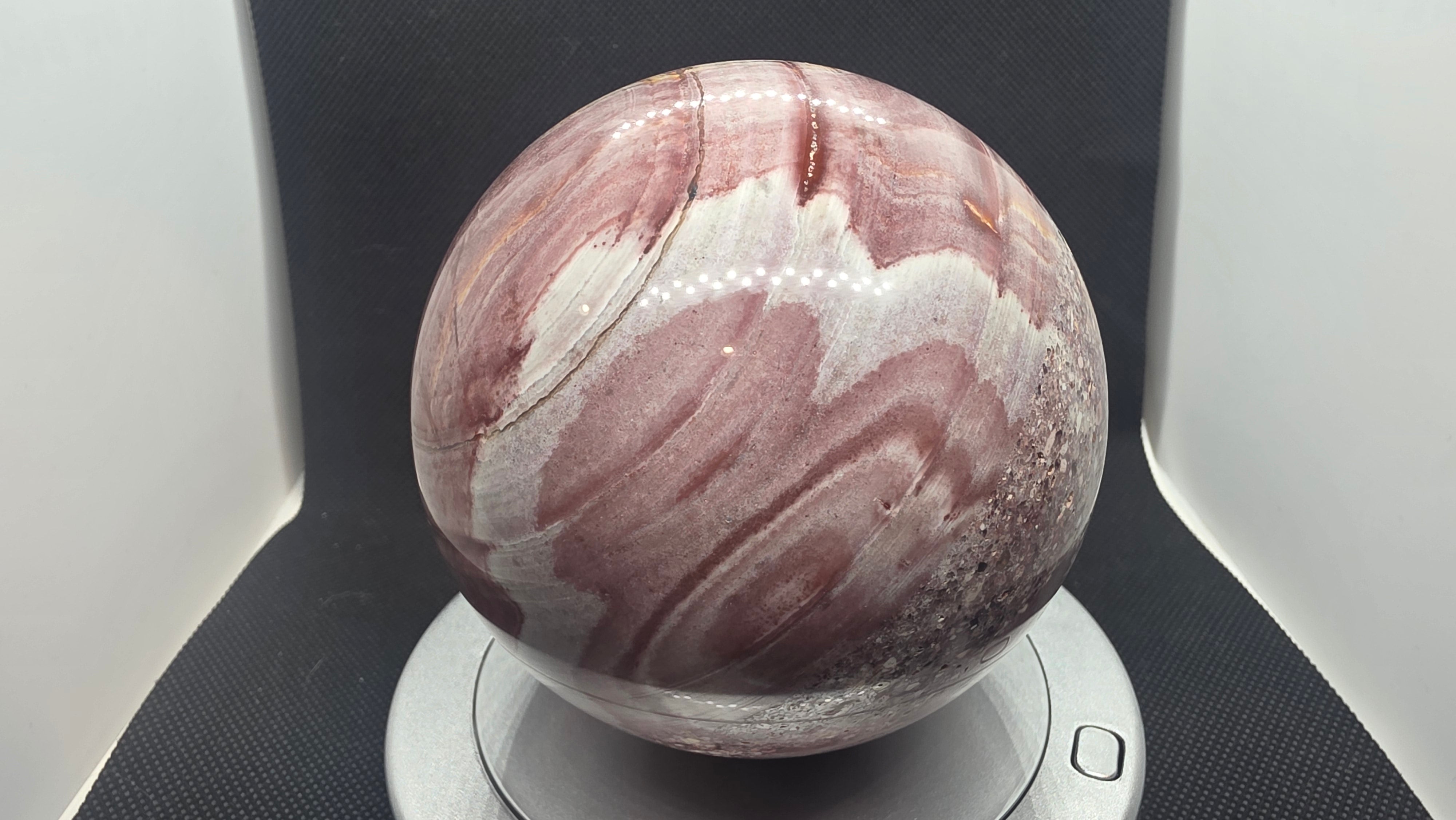 Banded ryolite (Wonderstone) sphere – minerals in motion